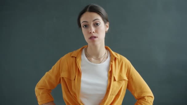 Portrait of angry young woman looking at camera with displeased face and speaking standing alone — Stock Video