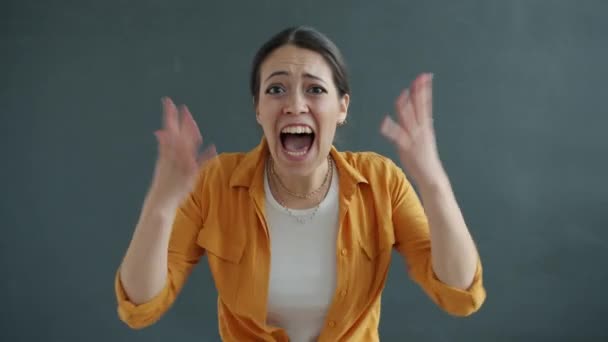 Retrato de una jovencita gritando y haciendo gestos mirando a la cámara luchando expresando rabia — Vídeo de stock
