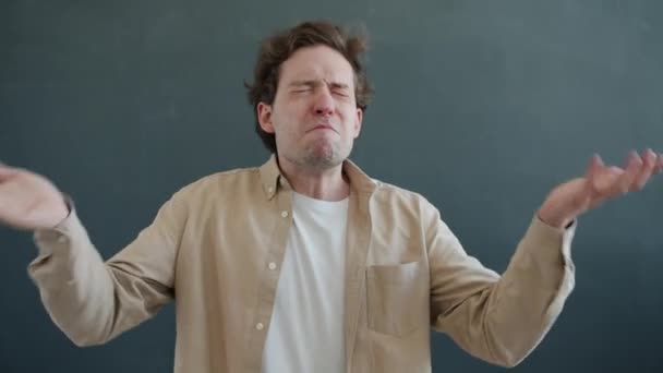 Zpomalený film portrét vystresovaného mladého muže křičící a mávající pažemi pak se dívá do kamery — Stock video
