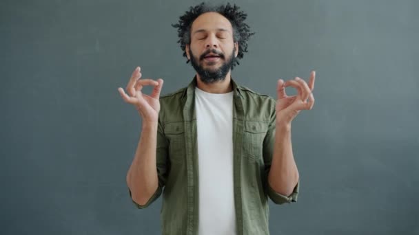 Powolny portret oświeconej rasy mieszanej człowiek medytujący trzymając się za ręce w namaste gesty — Wideo stockowe