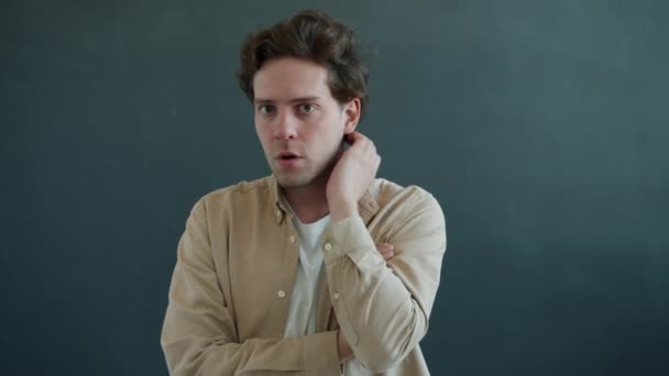 Slow motion portrait of male genius raising finger having great idea smiling on gray background — Stock Video