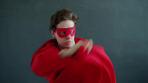 Lassú mozgás vicces srác szuper hős visel piros köpeny és maszk körülnézett, majd elfutott