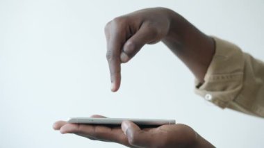 Beyaz arkaplanda akıllı telefon ekranına dokunan erkeklerin yavaş çekimde yakın çekim görüntüleri