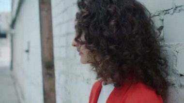 Kameraya dönüp dışarıda gülümseyen genç bir kadının yavaş çekimleri.