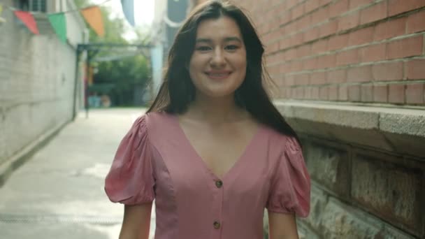 Retrato de atractiva asiática estudiante mostrando pulgares hacia arriba gesto de la mano y sonriendo al aire libre — Vídeos de Stock