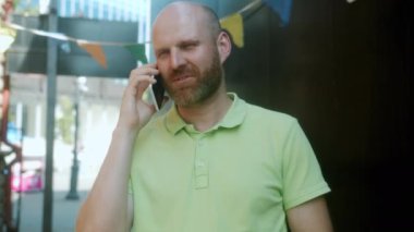 Neşeli genç adam cep telefonuyla konuşuyor ve gülümsüyor.