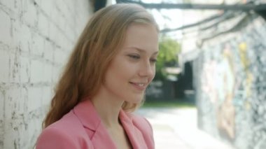 Güzel genç bayanın portresi kameraya dönüyor. Güzel bir gülümseme ile şehrin dışında duruyor.