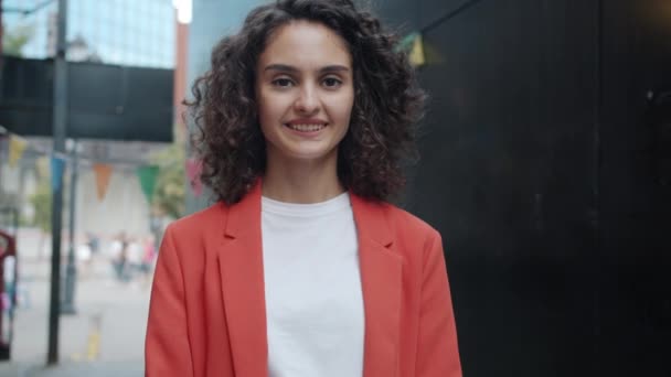 Langsom bevægelse portræt af attraktive unge forretningskvinde vinke hånd og smilende udenfor i byens gade – Stock-video