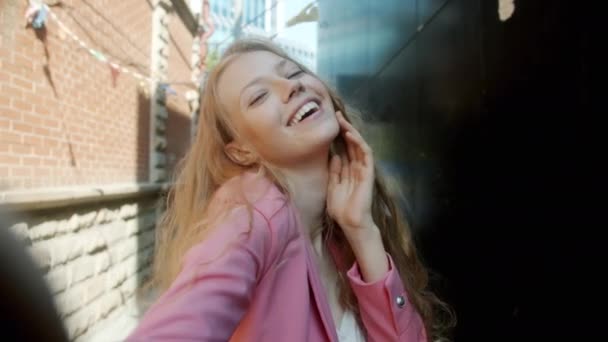 Portrét roztomilé mladé blondýny při selfie pózování s legrační tváře při pohledu na kameru venku — Stock video