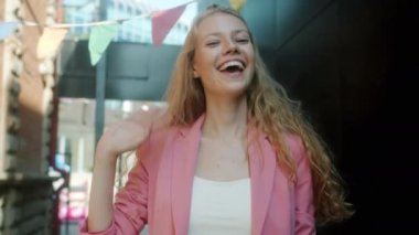 Güzel genç bir kadının portresi gülümseyen el sallayan şehir caddesinde tek başına duran