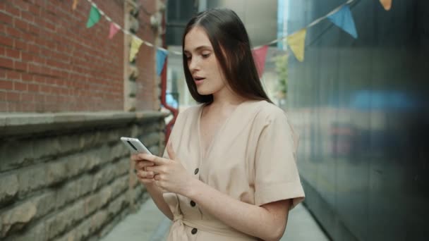 Retrato de mulher alegre recebendo ótimas notícias na mensagem de telefone inteligente rindo segurando dispositivo ao ar livre — Vídeo de Stock