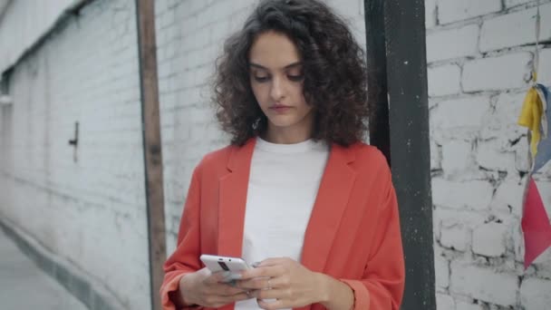 Slow motion porträtt av lyhörd ung affärskvinna med hjälp av smart telefon pekskärm utomhus — Stockvideo