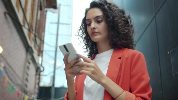Açık havada duran ekranda akıllı telefonla mesajlaşan sevimli genç iş kadınının portresi. — Stok video