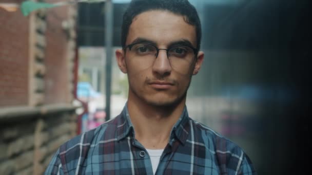 Retrato en cámara lenta de primer plano de un joven árabe guapo con gafas mirando a la cámara con cara seria — Vídeos de Stock
