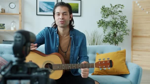 Yaratıcı genç gitarist evde gitar çalan modern kamerayla video kaydediyor. — Stok video