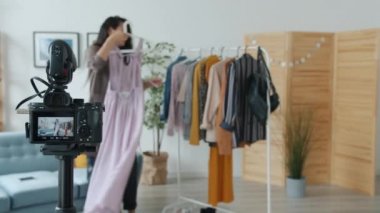 Moda blogcusu kıyafetlerle ilgili video kaydediyor ve sonra başparmakları kaldırıp kamerayı kapatıyor
