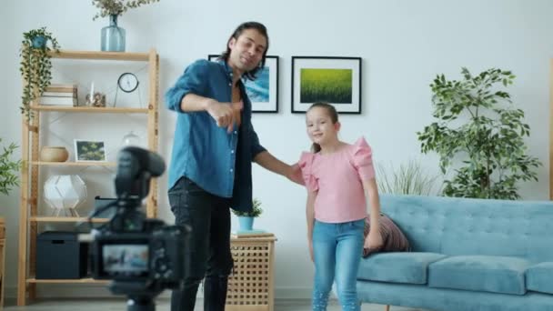 Joyful vader en dochter dansen zwaaiende hand doet high-five opname video voor internet blog — Stockvideo