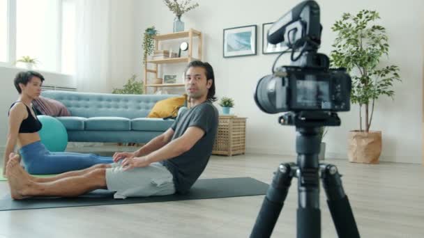 Vloggers masculins et féminins travaillant sur tapis de yoga enregistrement vidéo pour internet vlog à la maison — Video