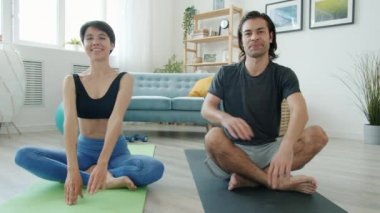 Nilüfer çiçeğinin önünde yoga yapan kız ve erkeğin portresi.