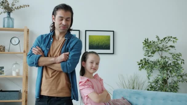 Retrato de hombre y niña de pie en el interior con los brazos cruzados sonriendo mirando a la cámara — Vídeos de Stock