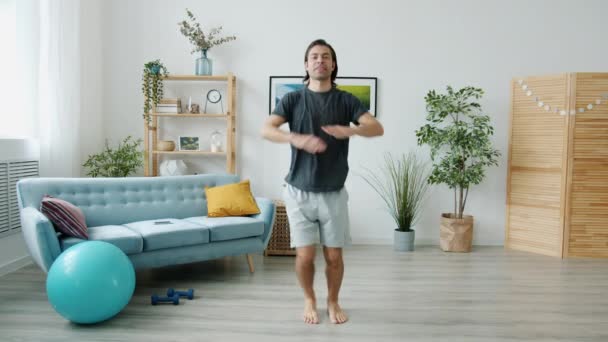 Retrato de un joven haciendo ejercicios deportivos y hablando mostrando un gesto de pulgares hacia arriba mirando a la cámara — Vídeo de stock