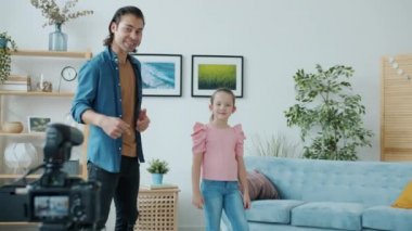 Evde video bloğu için dans eden ve konuşan küçük kız ve erkeğin yavaş çekim görüntüleri.