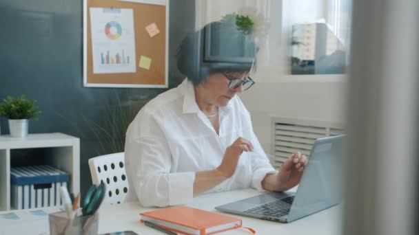 Serious business lady usando la escritura portátil concentrada en el trabajo corporativo en la oficina — Vídeos de Stock