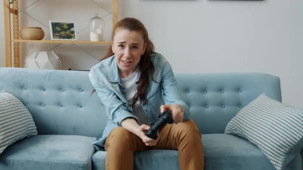 Πορτρέτο της ανέμελης νεαρή γυναίκα παίζει video game χάνει ρίχνοντας joystick στο σπίτι — Αρχείο Βίντεο