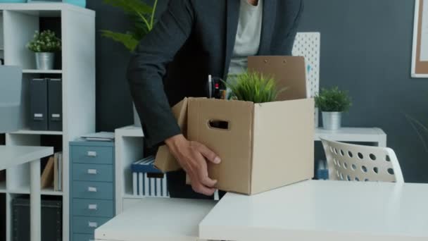 Nuevo oficinista que viene al escritorio con caja de cartón de pertenencias y luego trabaja con el portátil sonriendo — Vídeos de Stock