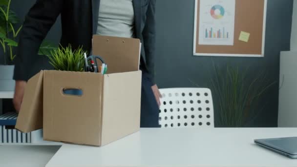 Ny medarbejder bringer kasse med ejendele til arbejdspladsen og arbejder med laptop smilende – Stock-video