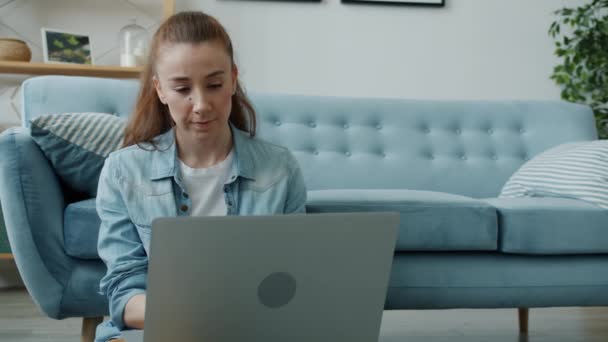 Movimento lento de bela jovem mulher usando laptop sentado no chão em casa — Vídeo de Stock