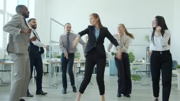 Atrakcyjna dziewczyna w garniturze taniec z kolegami relaks na imprezie firmowej uroczystości — Wideo stockowe