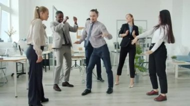 Çok ırklı takım dansının yavaş çekimleri iş yerinde birlikte eğleniyor.