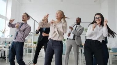 Ofiste dans eden yaratıcı çalışanların kameraya bakan mutlu yüzleri.