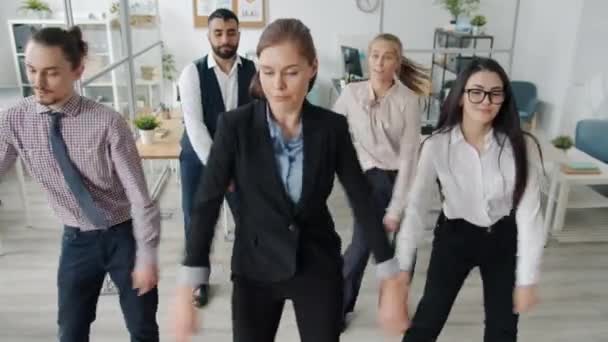 Vista de alto ángulo de gente alegre compañeros de trabajo bailando en el lugar de trabajo disfrutando de la música y la actividad — Vídeos de Stock