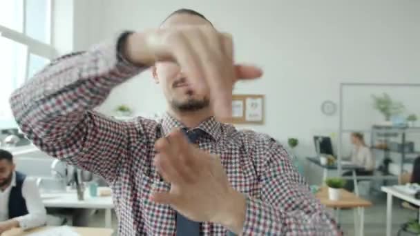 Забавный молодой человек танцует двигая руками, затем идет на работу в офис — стоковое видео