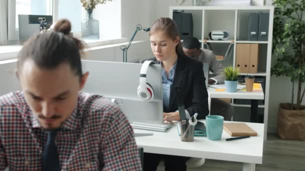 Movimiento lento de empleados multiétnicos que trabajan con computadoras en la oficina — Vídeos de Stock