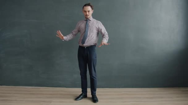 Zeitlupe eines kreativen Geschäftsmannes, der vor schwarzem Hintergrund tanzt — Stockvideo