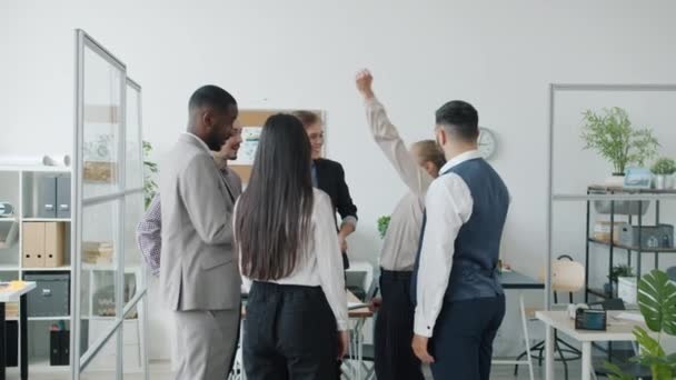 Kreatywny zespół biznesowy przytulanie i skoki dobrze się bawiąc i ciesząc teambuilding w biurze — Wideo stockowe