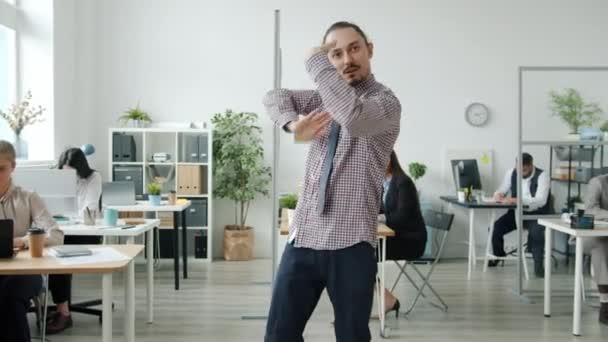 Zabawny pracownik tańczy w biurze, a potem dołącza do niego drużyna biznesowa. — Wideo stockowe