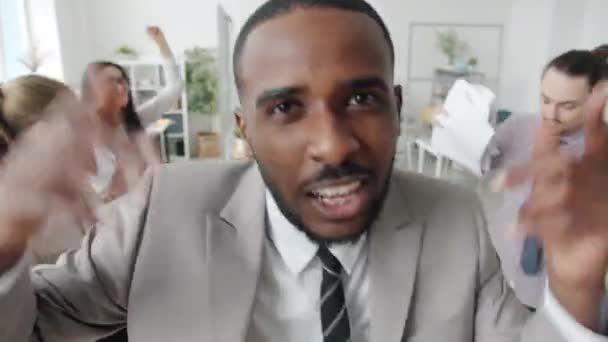 Rap sångare talar till musik tittar på kameran medan företagare dansar i bakgrunden — Stockvideo