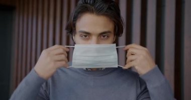 Tek kullanımlık tıbbi maske takan yakışıklı bir Arap 'ın portresi