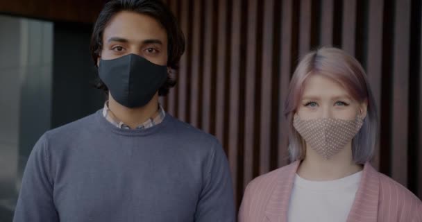 Portret van een Arabische man en een blanke vrouw met gezichtsmasker tijdens de covid-19 pandemie — Stockvideo