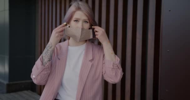 Portret van mooie jonge blonde zetten op herbruikbare masker binnen thuis — Stockvideo