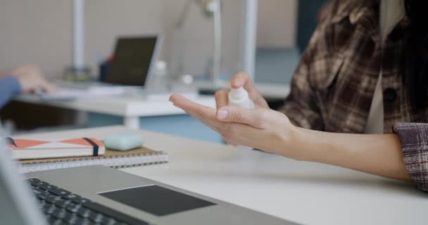 Közelkép egy nőről, aki kezet mos fertőtlenítővel, majd laptoppal dolgozik az irodában. — Stock videók