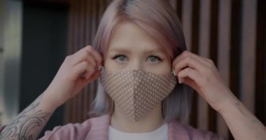 Neşeli kız yeniden kullanılabilir koruyucu maskeyi çıkarıyor ve mutlu bir gülümsemeyle nefes alıyor.