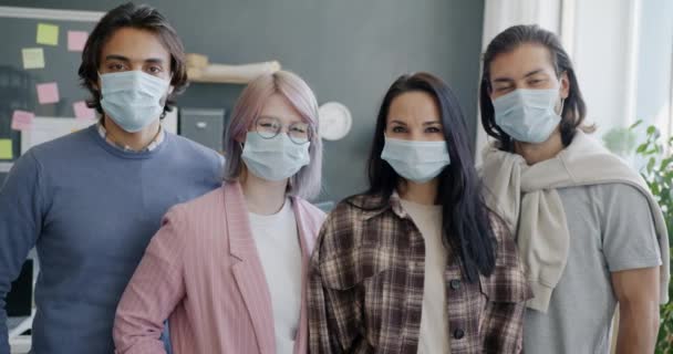 Groupe diversifié de personnes collègues debout dans le bureau portant des masques médicaux — Video