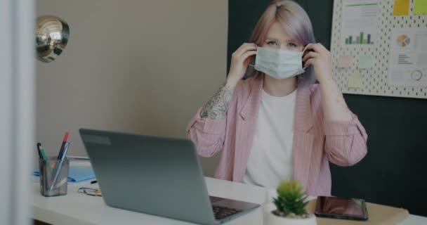 Portrait de jeune femme d'affaires portant un masque facial au bureau pendant la pandémie de covidé-19 — Video