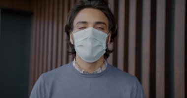 Arap 'ın ağır çekim portresi. Tıbbi maskesini çıkarıyor ve içeride derin derin nefes alıyor.