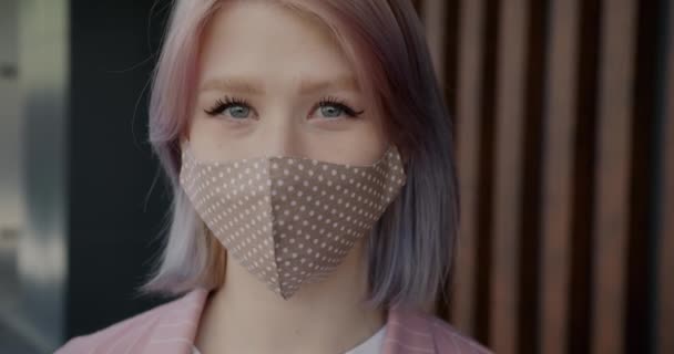 Close-up slow motion portret van leuke blonde dragen herbruikbare gezichtsmasker binnen — Stockvideo